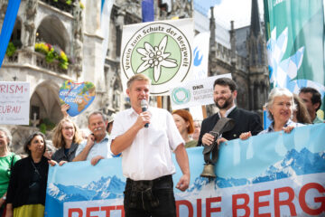 ÖDP-Landesvorsitzender Tobias Ruff (vorne, mit Mikro) wirbt am Marienplatz in München für den Schutz der Bergwelt. Foto: Lukas Barth-Tuttas